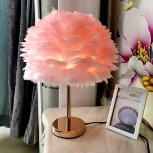 Lampe plume : une décoration lumineuse élégante et originale 5 Lampe à poser en plumes roses avec pied doré et éclairage chaleureux