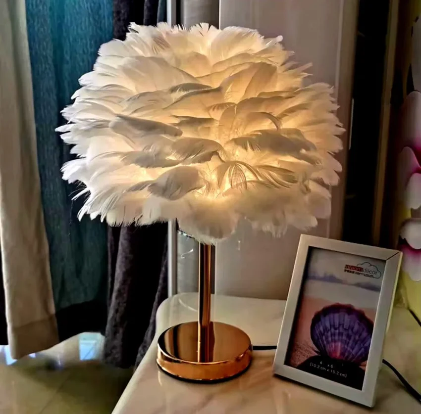 Lampe plume : une décoration lumineuse élégante et originale 1 Lampe de table en plumes blanches avec pied doré et lumière douce